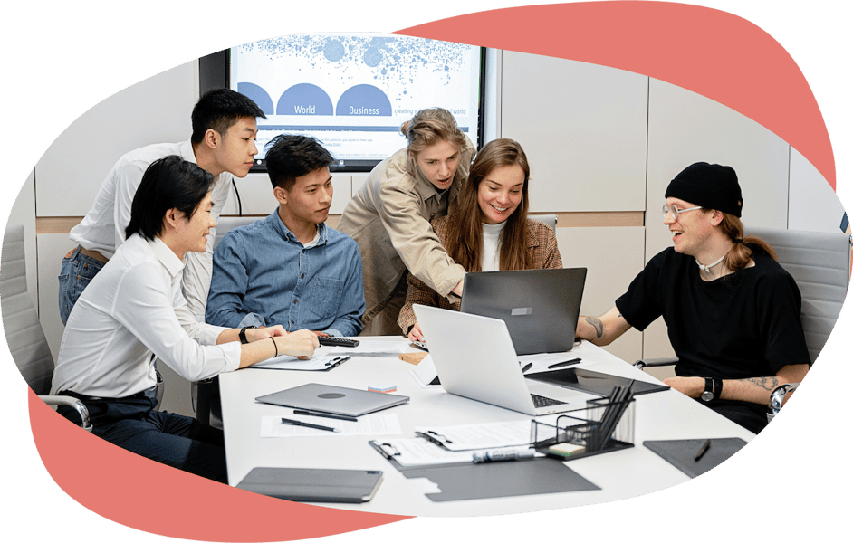 A team collaborating around a table and smiling A team collaborating around a table and smiling
