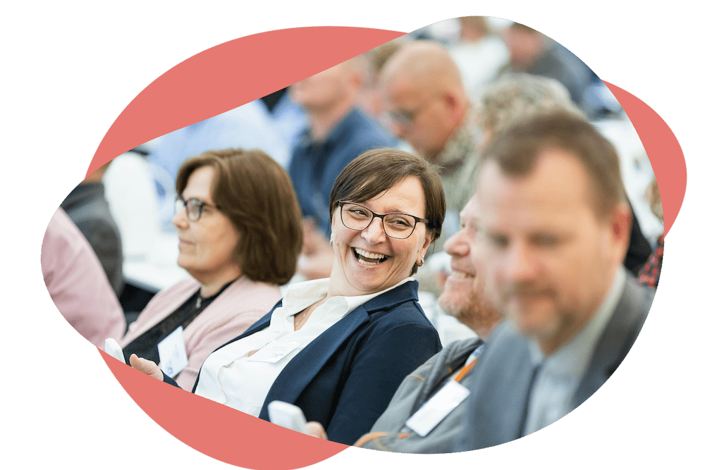 Audience members engaged and smiling during a session