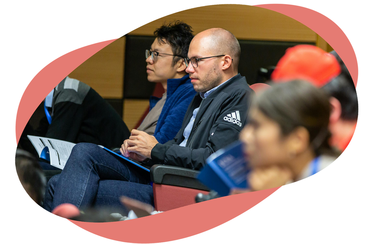 Audience members in an auditorium taking notes