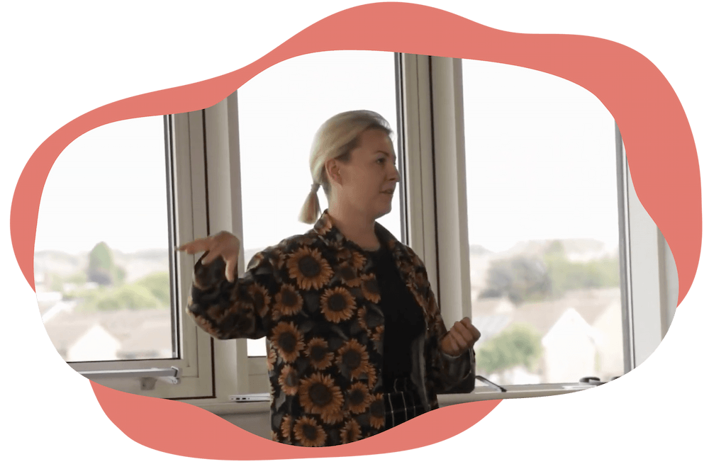 Jess in a sunflower jacket explaining something