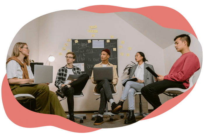 Small group discussion with laptops and notes in a meeting room