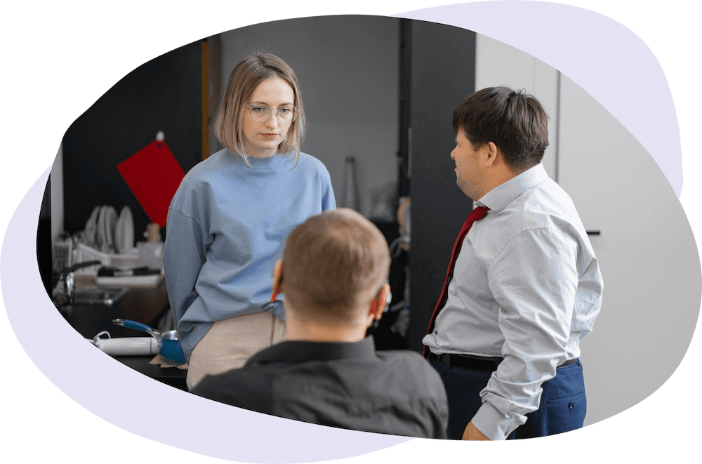 Three people having a conversation at work in a communal kitchen