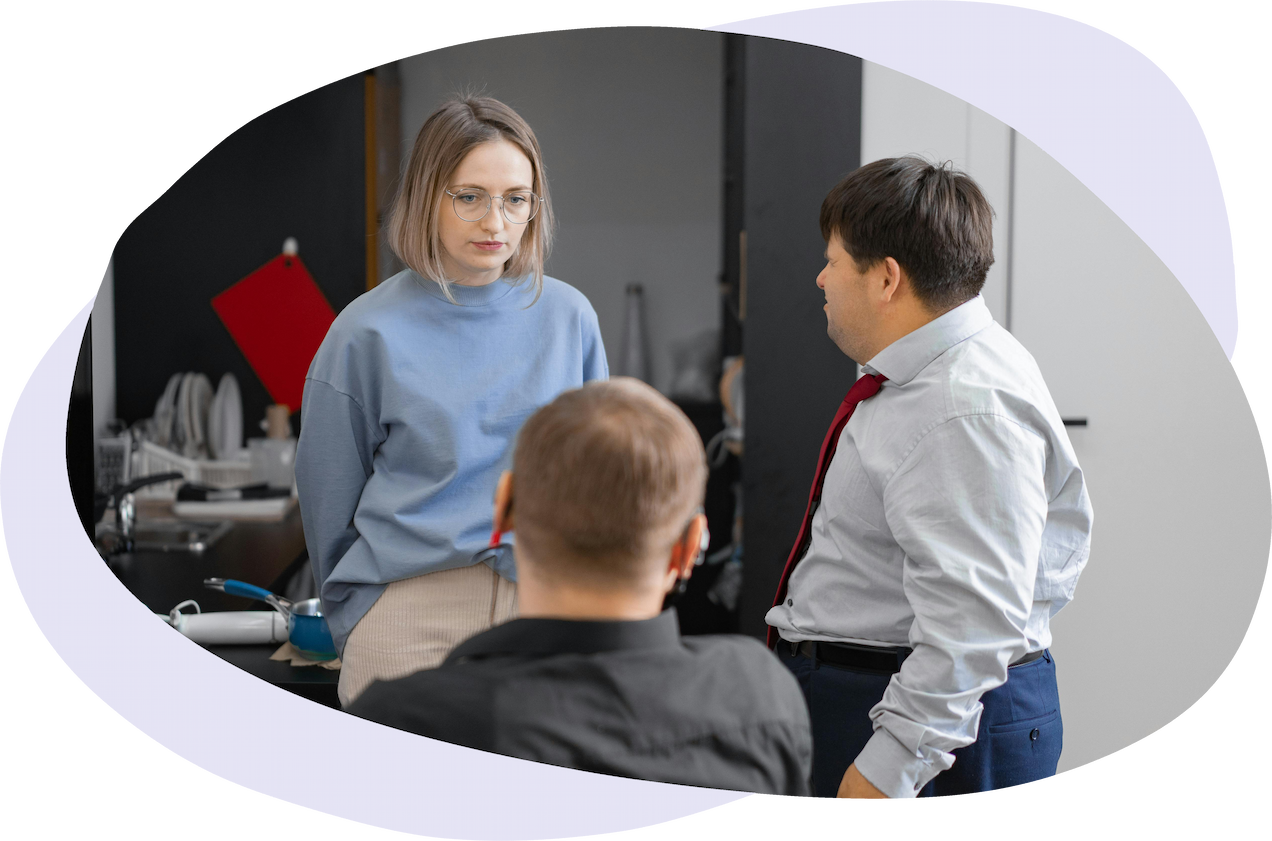 Three people having a conversation at work in a communal kitchen