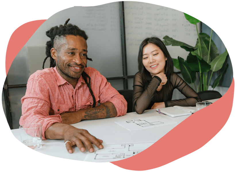 Two people sat at a shared work table looking at documents