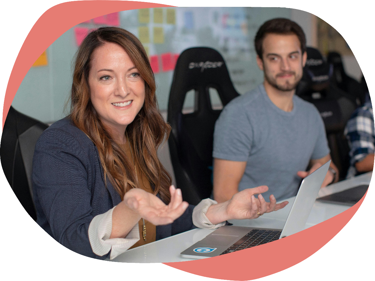 Two people sat at a desk with laptops and sticky notes
